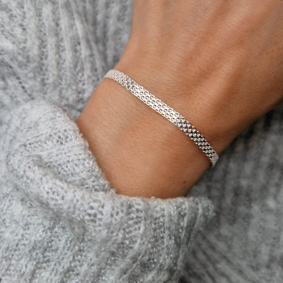Breites 925 Silberarmband Mesh Armband am Handgelenk des Models in Nahaufnahme mit grauem Pulli
