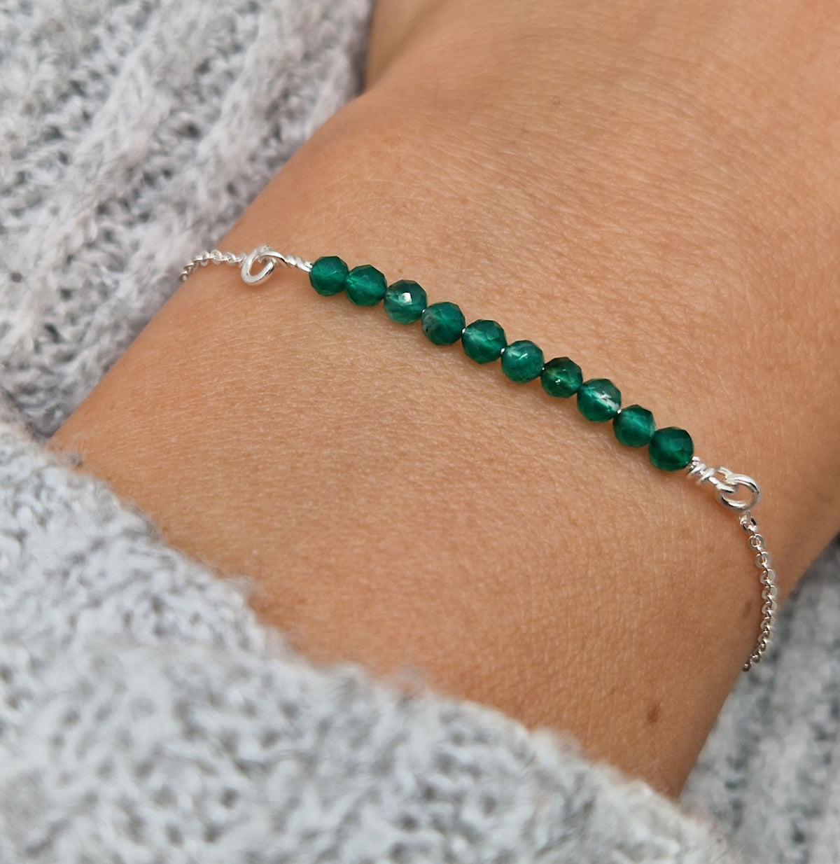 Filigranes Silber-Armband 925 mit grünen Achat Naturstein-Perlen facettiert am Handgelenkdes Models in seitlicher Nahaufnahme