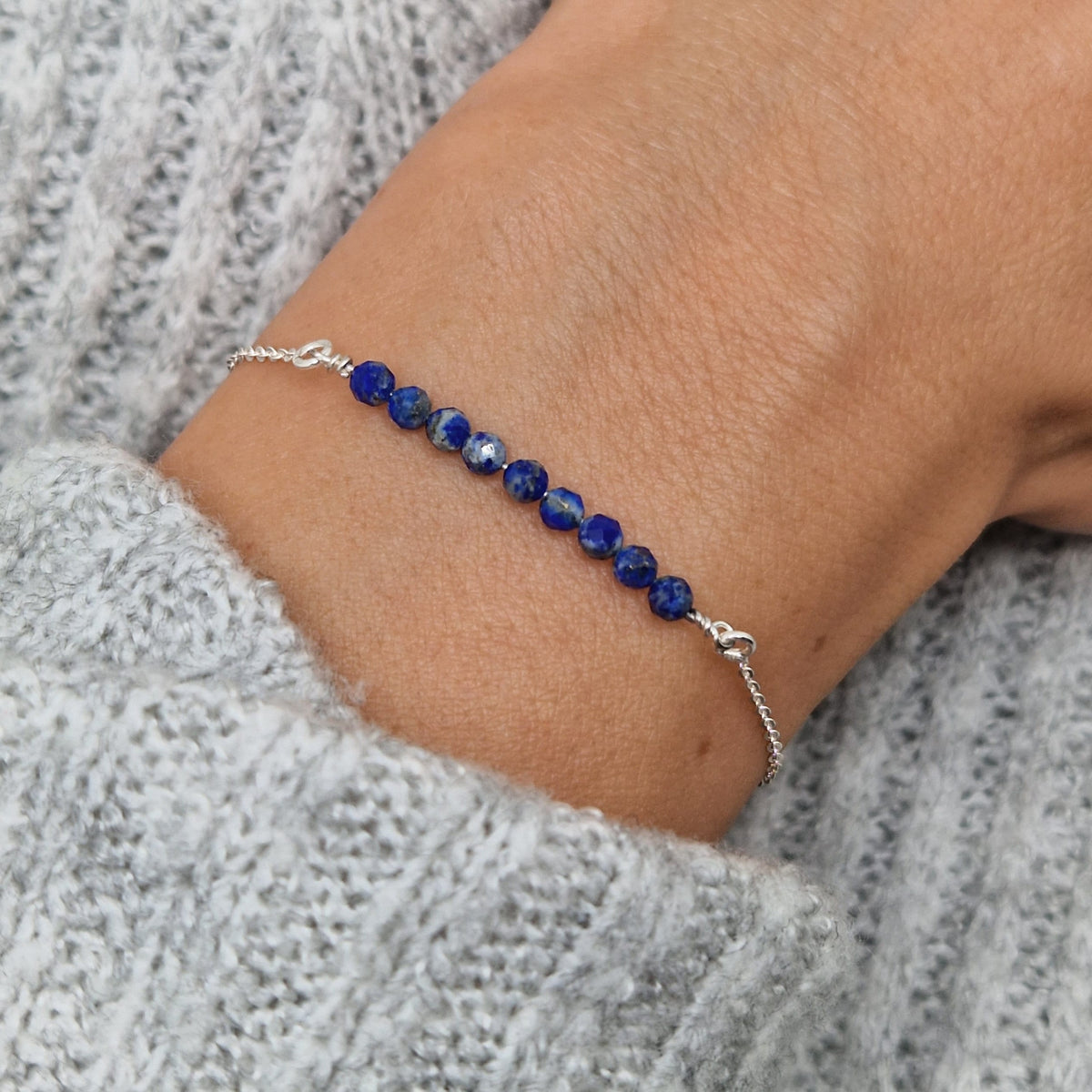 Filigranes Silber-Armband 925 mit blauem Lapislazuli Naturstein-Perlen facettiert am Handgelenkdes Models in Nahaufnahme