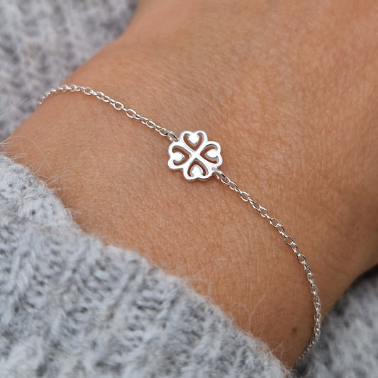 Zartes Silberarmband mit Kleeblatt Anhänger am Handgelenk des Models in seitlicher Nahaufnahme mit grauem Pulli