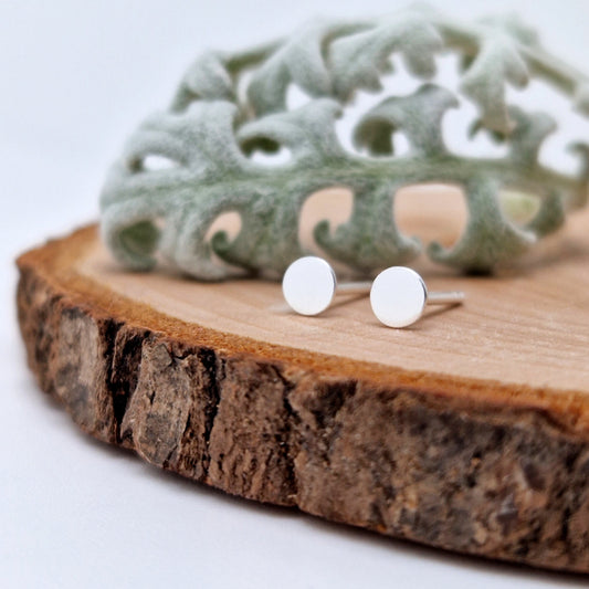 Kleine Ohrstecker in Kreis-Form aus 925 Sterling Silber auf einer Holzscheibe mit Blättern 3,0mm