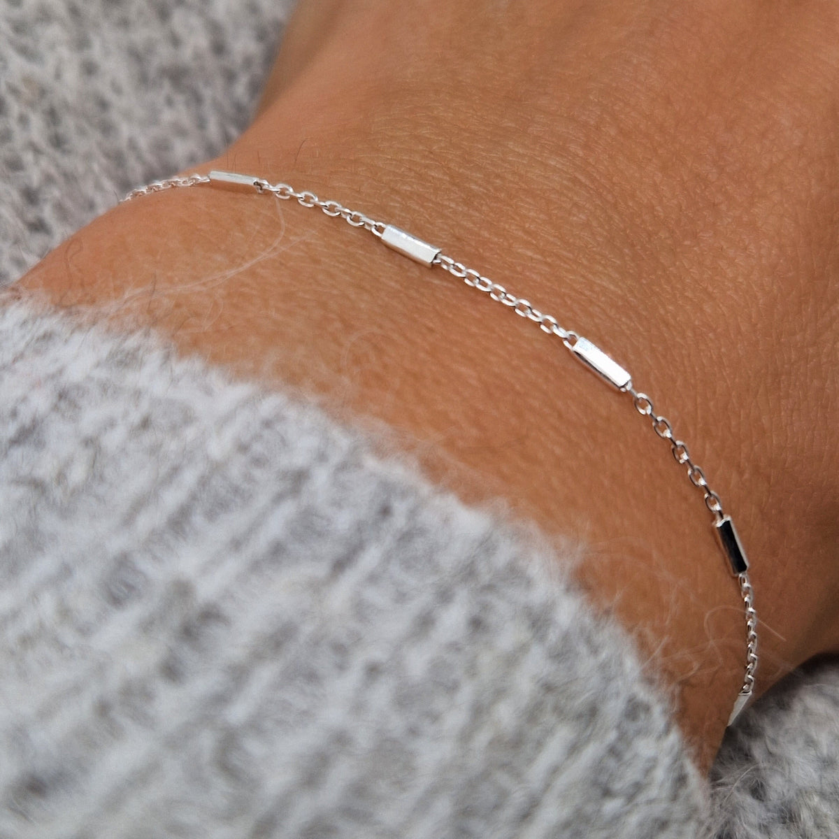 Zartes 925-Silber-Satelliten-Armband mit Balken am Handgelenk des Models in seitlicher Nahaufnahme
