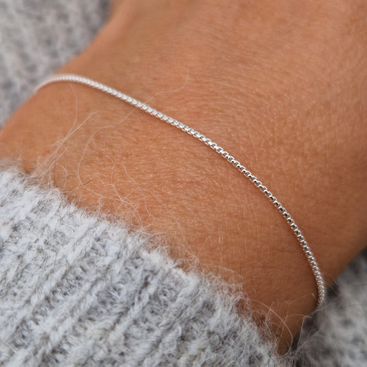 Sehr feines schmales zartes Silberarmband im abgerundeten Venezianer Stil am Handgelenk des Models in seitlicher Nahaufnahme