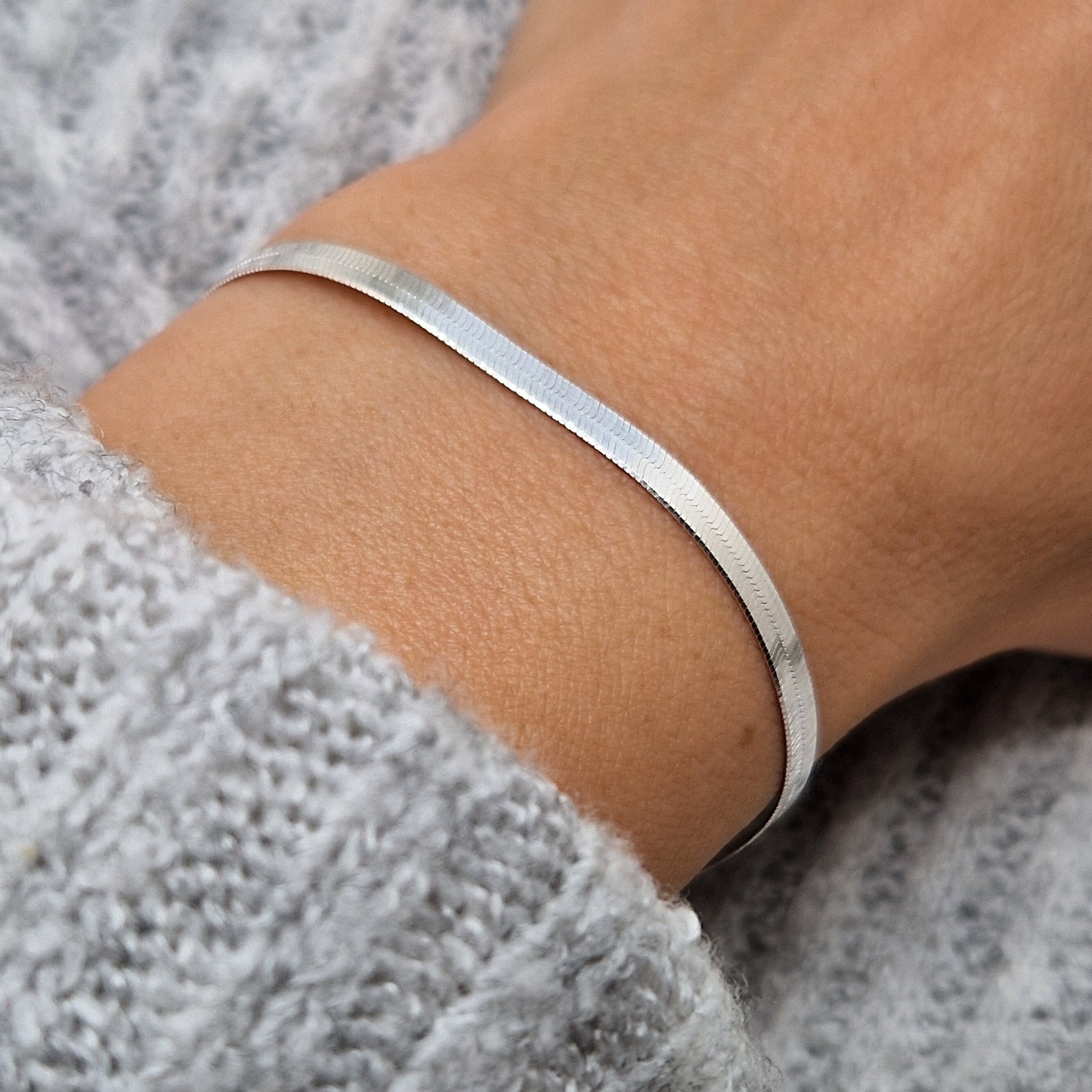Schlangenarmbandflach Herringbone 3mm 925 Silber am Handgelenk des Model in seitlicher Nahaufnahme