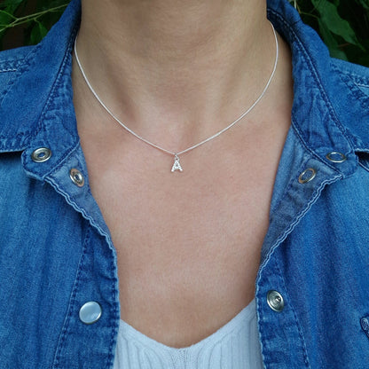 Zarte 925 Silber-Halskette Curb mit Anhänger Buchstabe A mit Zirkonia Kristallen am Hals des Models in Nahaufnahme
