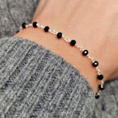 Silber Armband mit schwarzen facettierten  Spinell Perlen am Handgelenk des Models in seitlicher Nahaufnahme