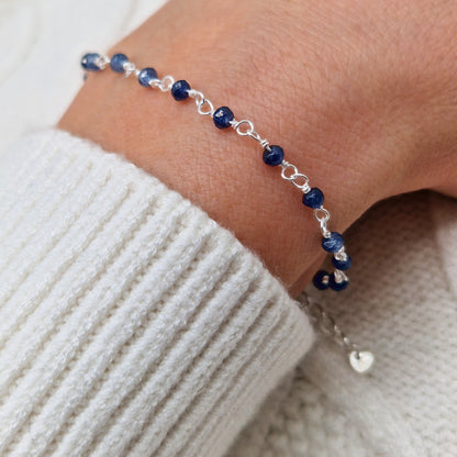 zartes Silber Armband mit dunkelblauen Jade Perlen aus Naturstein am Handgelenk des Models