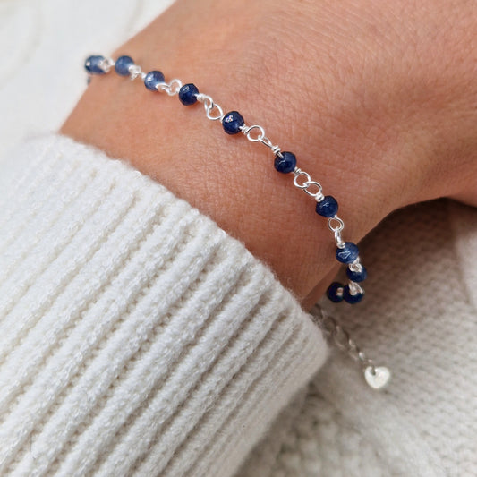 zartes Silber Armband mit dunkelblauen Jade Perlen aus Naturstein am Handgelenk des Models