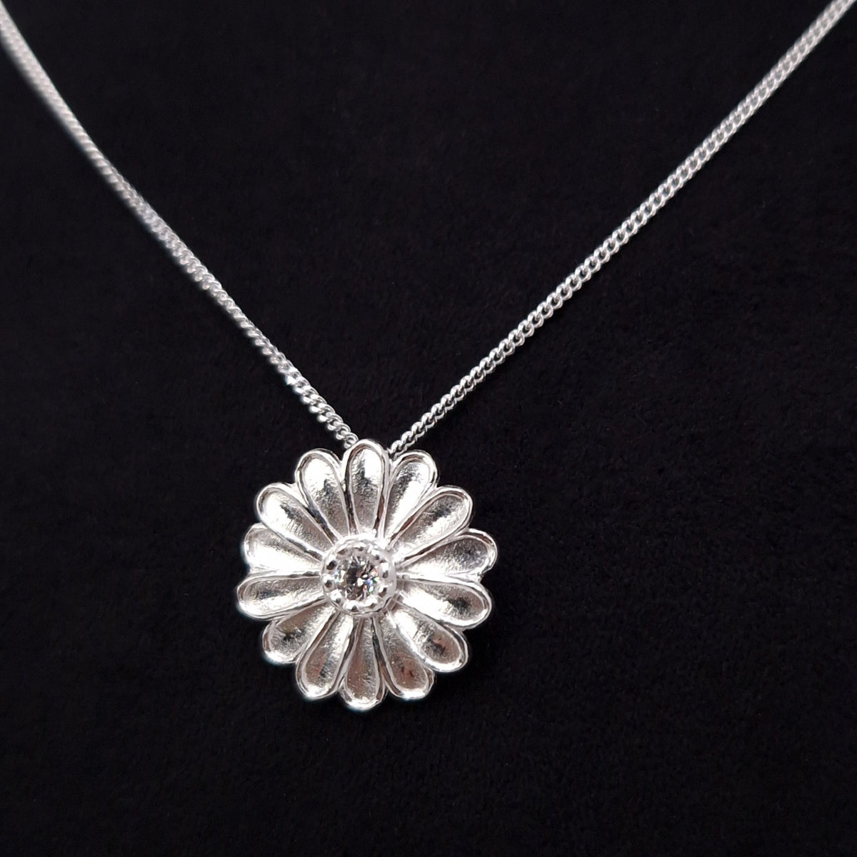Curb Halskette mit Anhänger große Margeritenblüte aus massivem 925 Sterling Silber. Die Blütenblätter sind plastisch ausgeformt rund um die Blütenmitte angeordnet.
