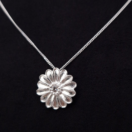 Curb Halskette mit Anhänger große Margeritenblüte aus massivem 925 Sterling Silber. Die Blütenblätter sind plastisch ausgeformt rund um die Blütenmitte angeordnet.