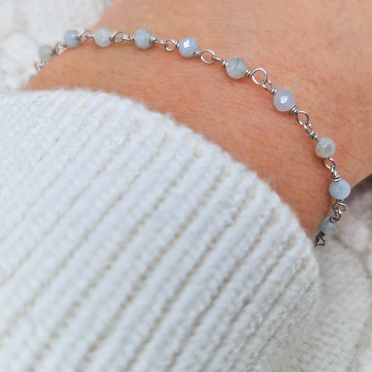 zartes Silber Armband mit grau blauen facettierten Aquamarin  Perlen aus Naturstein am Handgelenk des Models
