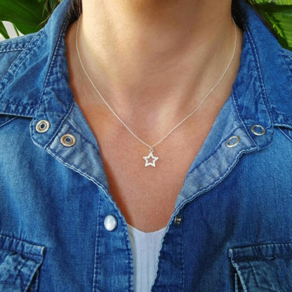 Halskette 925 Silber mit mittelgroßem Stern Anhänger mit Zirkonia Kristallen hohl am Hals des Models mit Jeansbluse und weißem Top