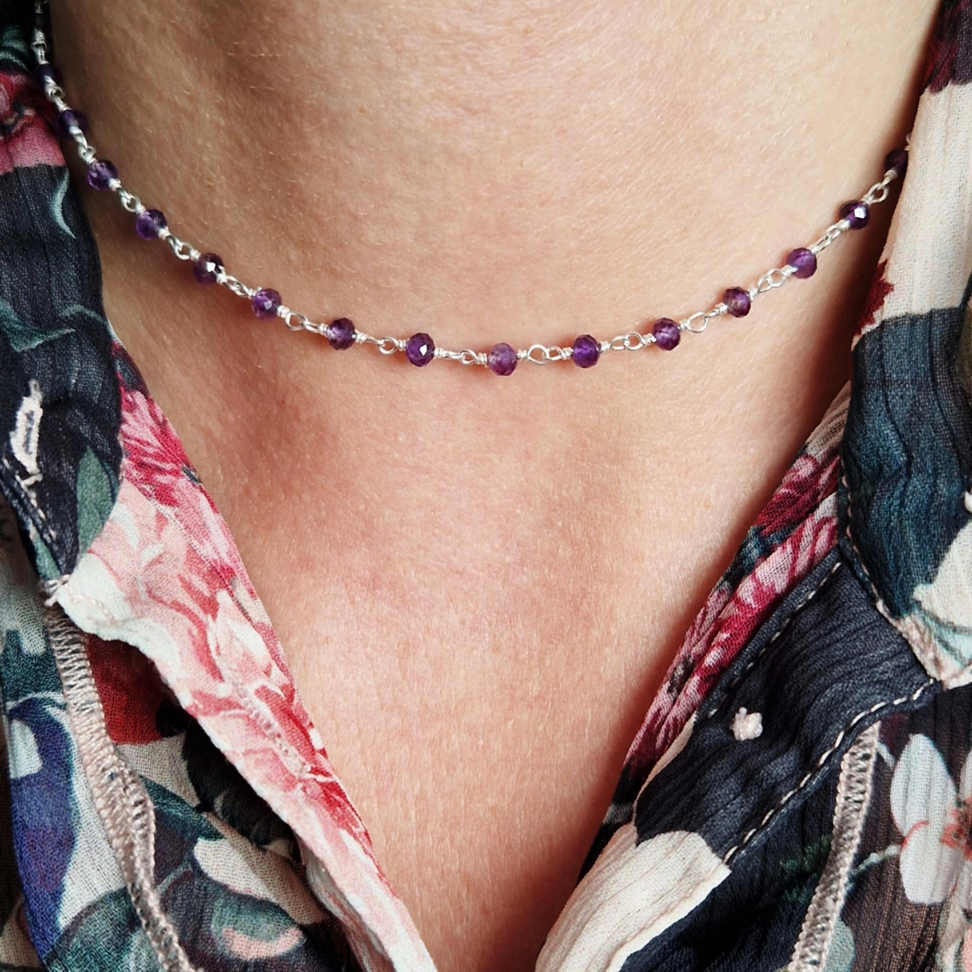 zarte  925 Silber Halskette
mit lila facettierten Amethyst Perlen aus Naturstein am Hals des Models in frontaler Nahaufnahme mit floraler Bluse