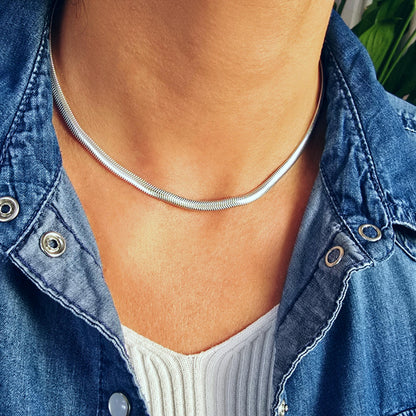 Gewölbte Schlangenkette Herringbone aus massivem 925 Sterling Silber Breite 4,3 mm in Nahaufnahme am Hals des Models