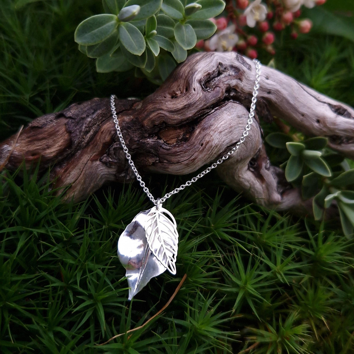 Silberhalskette mit Blatt zwei Anhängern aus massivem 925 Sterling Silber ein Blatt skelettartig und ein Blatt massiv gewölbt fotografiert auf Holz und Sternmoos